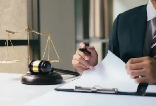 A man sitting in the court signing papers.