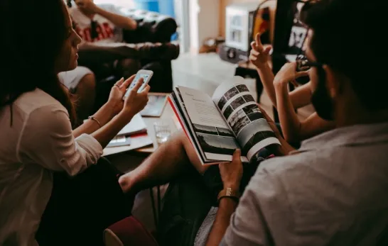 a group of people sitting using laptop and mobile