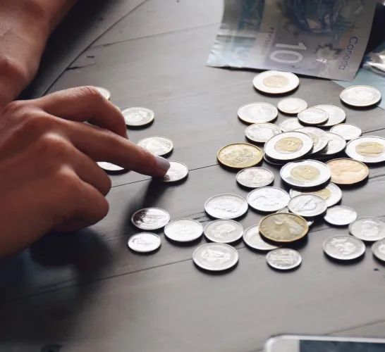 coins on a table been counted by a hand